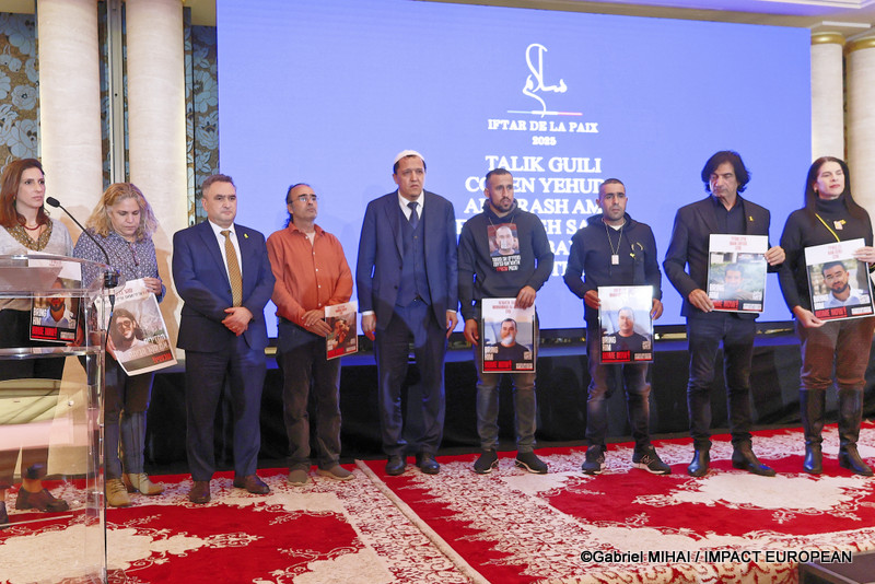L'ambassadeur d'Israël à Paris Joshua Laurent Zarka (3e à partir de la gauche), l'imam Chalghoumi (5e à partir de la gauche) et les familles des otages montrant les portraits des parents disparus