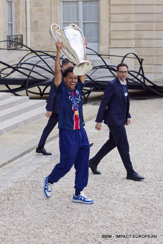 Le capitaine du PSG, Marquinhos, portant la coupe de la ligue des champions à l’Élysée