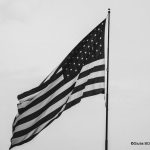 Drapeau américain en noir et blanc symbolisant le décès d’Alex Pretti par ICE