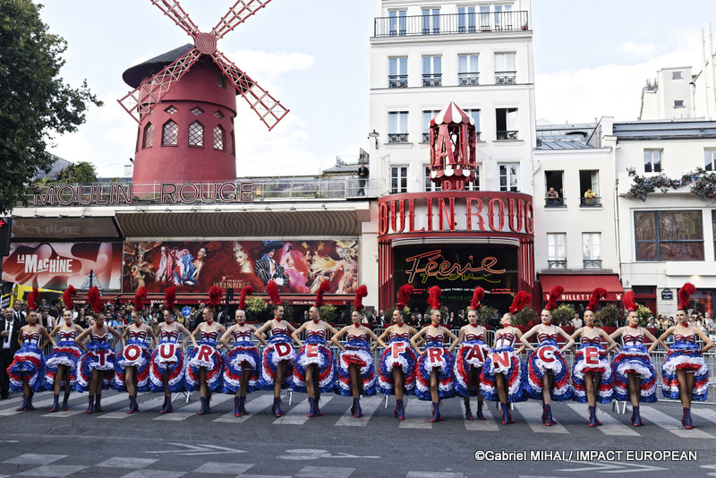 Les danseuses du Moulin Rouge présentent une chorégraphie en formant l'inscription « TOUR DE FRANCE » devant le cabaret de la place Blanche à Paris.