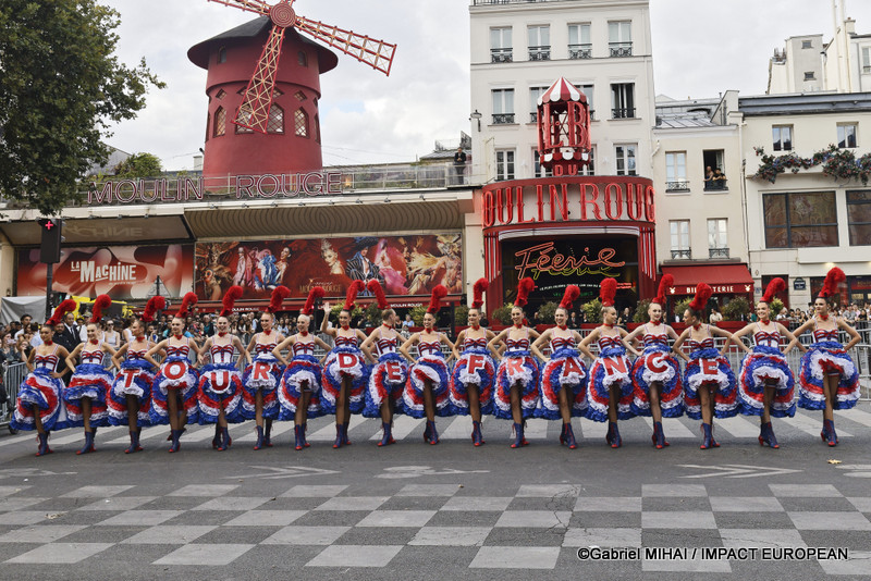 Les danseuses du Moulin Rouge présentent le tableau final « TOUR DE FRANCE » devant le célèbre cabaret de la place Blanche avant le passage des coureurs.