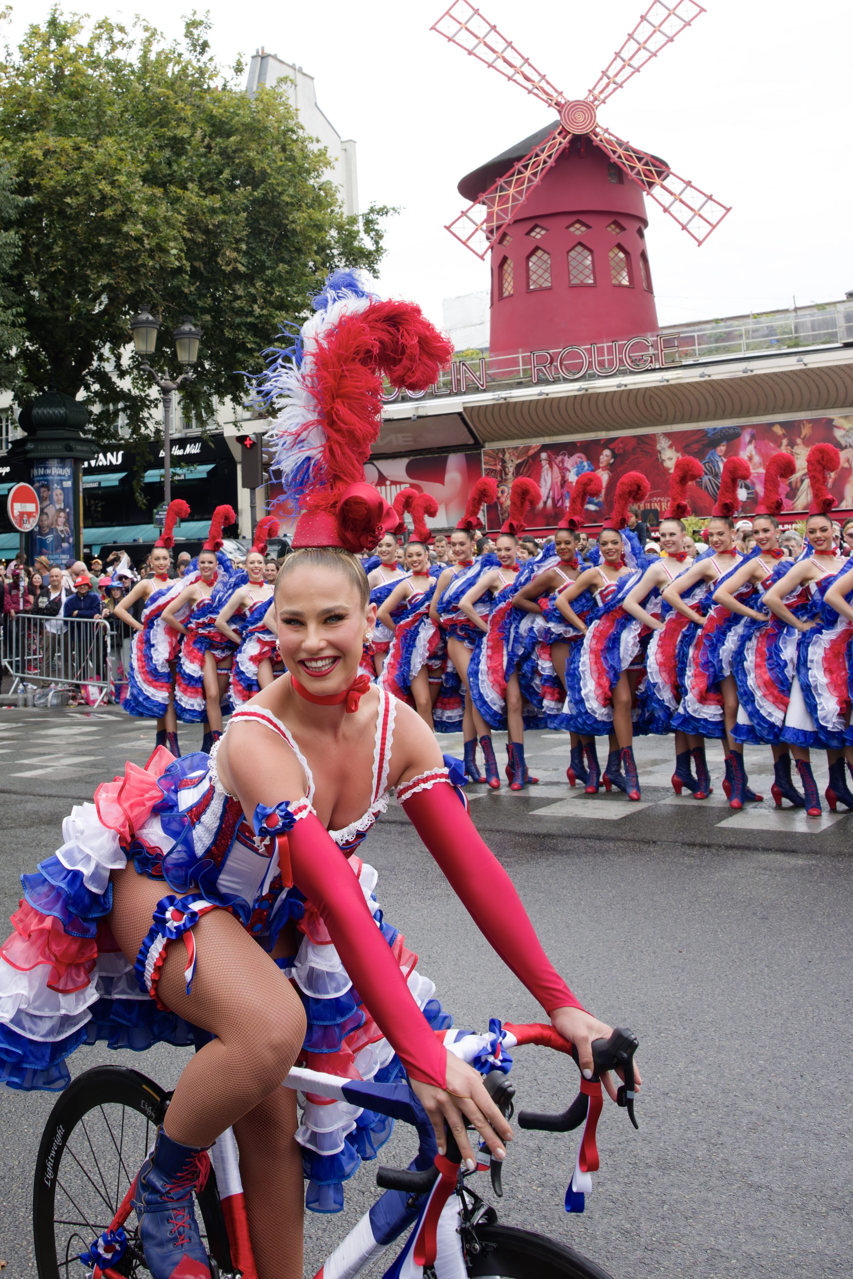 Jasmine Bard, danseuse au Moulin Rouge sur un vélo pour le Tour de France - Danseuses du Moulin Rouge en costume French Cancan devant le Tour de France - Copyright Philippe Wojazer - Moulin Rouge